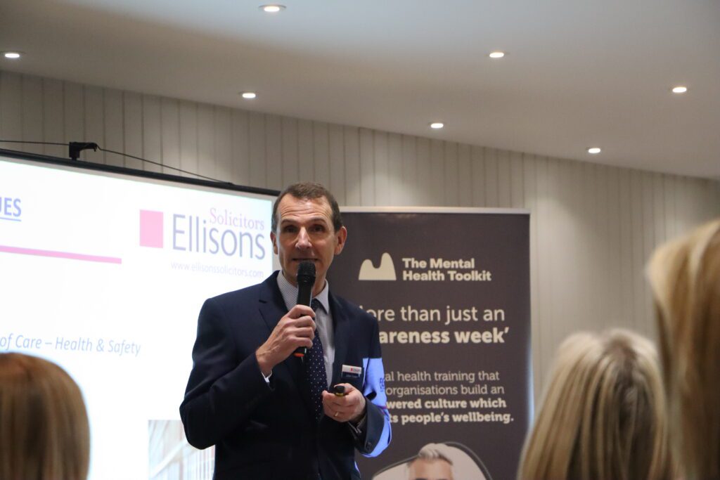 Man holding microphone standing in front of a crowd, public speaking